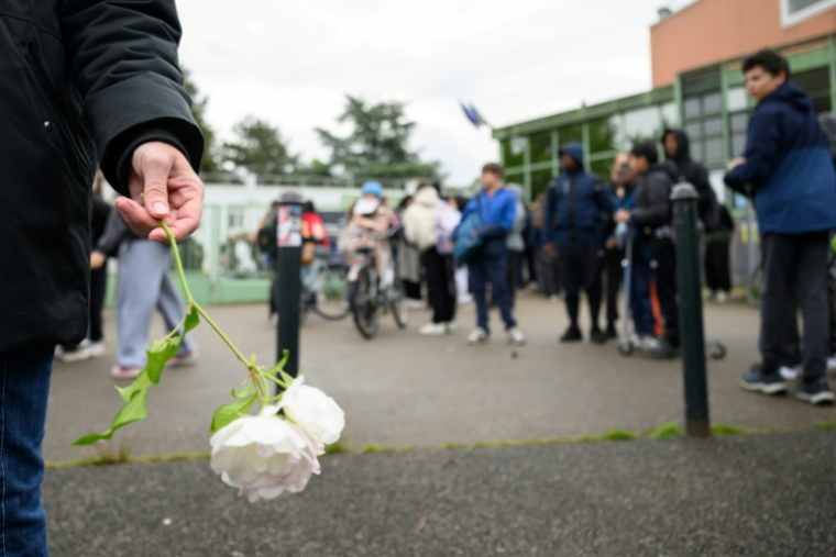 Des élèves du collège Libertaire Rutigliano rendent hommage à l'adolescent de 15 ans tué lors d'une fusillade, le 18 mai 2026 à Nanteshommage with flowers to pay tribute to a teenager who was shot and killed on May 14, as two other minors were wounded in the Port-Boyer neighborhood in Nantes, which had already been hit by deadly shootings linked to drug trafficking at the end of April, in Nantes, western France, on May 18, 2026. ( AFP / Loic VENANCE )