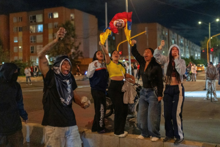 Des manifestants brandissent des drapeaux et tiennent des pierres lors d'affrontements liés aux résultats préliminaires du second tour de l'élection présidentielle à Bogota, en Colombie, le 21 juin 2026 ( AFP / Diego Cuevas )