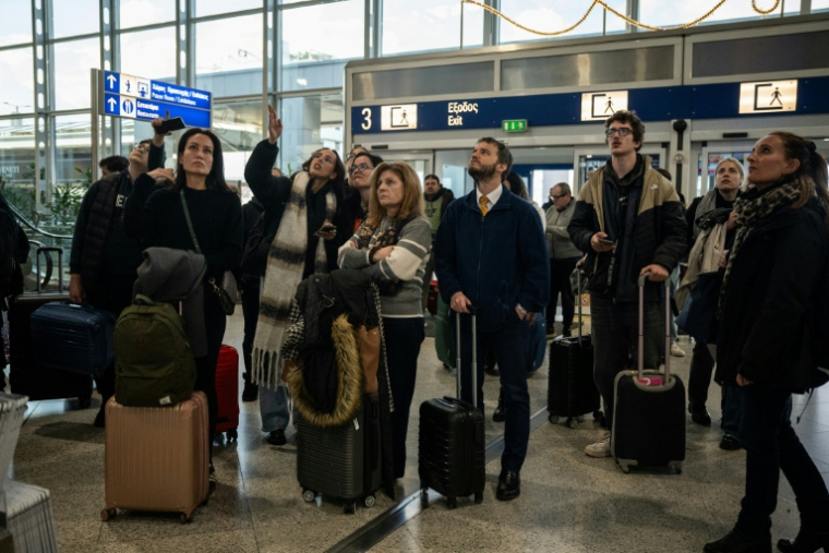 Des voyageurs attendent à l'aéroport d'Athènes-Spata après des retards et des reports de vols dans le pays dus à un "problème technique", le 4 janvier 2026 ( AFP / Angelos TZORTZINIS )