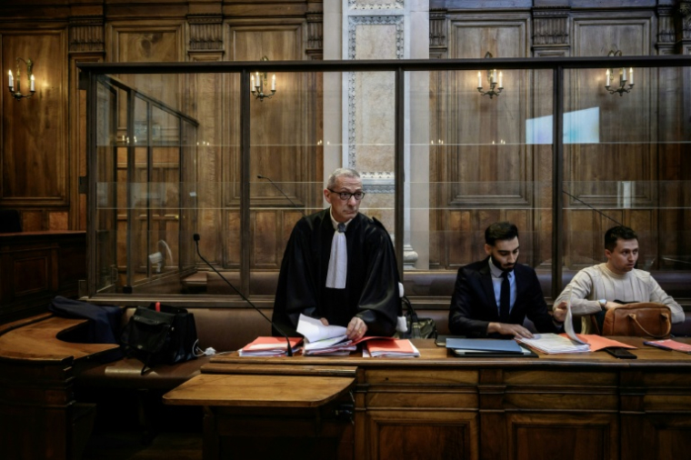 L'avocat de la défense Gabriel Versini (G) se prépare avant l'ouverture du procès de son client accusé de viol par soumission chimique, à Lyon le 11 juin 2026 ( AFP / Jeff PACHOUD )