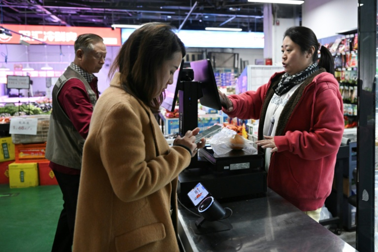 Des clients dans un supermarché à Pékin, le 20 octobre 2025 ( AFP / Pedro PARDO )