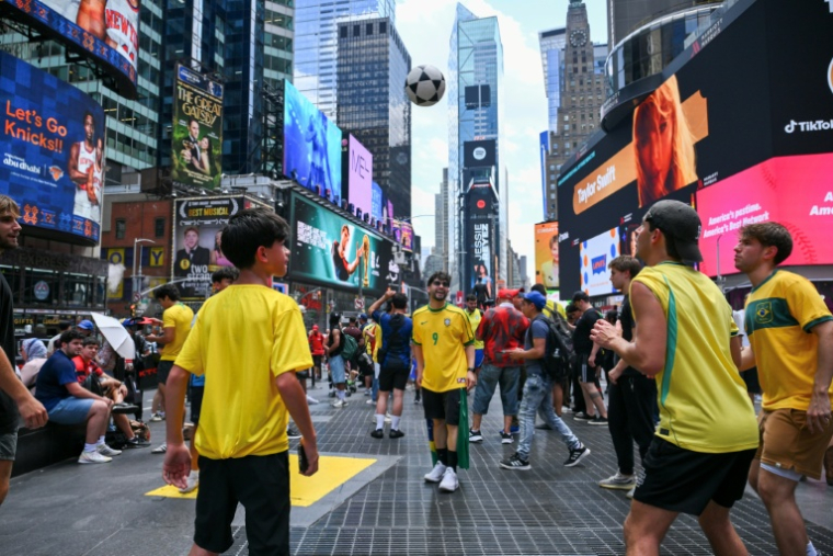 Des supporters brésiliens jouent au foot à Times Square, à New York, le 12 juin 2026 ( AFP / ANGELA WEISS )