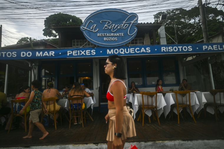 Une femme passe devant le restaurant Le Bardot à Buzios, au Brésil, le 3 janvier 2026 ( AFP / MAURO PIMENTEL )