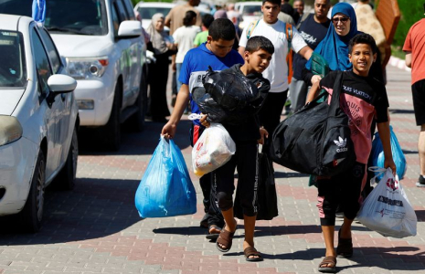 Photo des familles de membres du personnel d'organisations internationales transportent leurs affaires pour se réfugier dans un centre des Nations Unies après que l'UNRWA a annoncé avoir transféré son centre d'opérations central au sud de la bande de Gaza