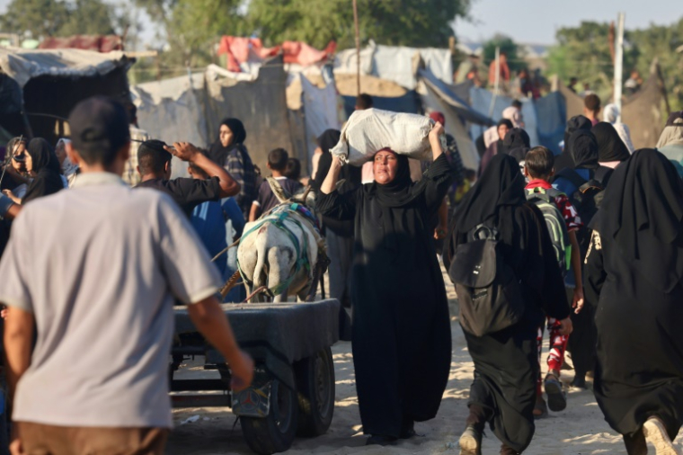 Une Palestinienne porte un sac d'aide humanitaire reçu à un point de distribution à Rafah, le 24 juillet 2025 dans le sud de la bande de Gaza ( AFP / - )