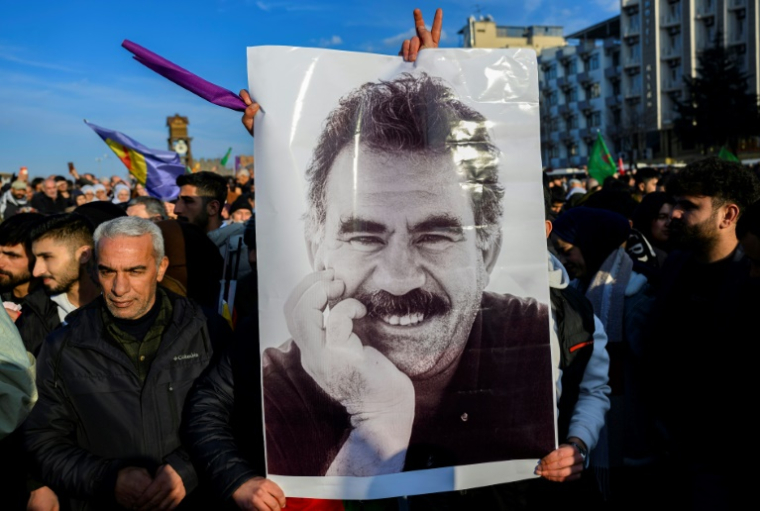 Des partisans du Parti des travailleurs du Kurdistan (PKK) brandissent un portrait du chef emprisonné du parti, Abdullah Ocalan, le 27 février 2025 à Diyarbakir, dans le sud-est de la Turquie PKK arborent une affiche représentant le chef emprisonné du Parti des travailleurs du Kurdistan (PKK), Abdullah Ocalan, 75 ans, après avoir appelé le Parti des travailleurs du Kurdistan (PKK) à se désarmer et à se dissoudre à Diyarbakir, dans le sud-est de la Turquie, le 27 février 2025. ( AFP / Yasin AKGUL )