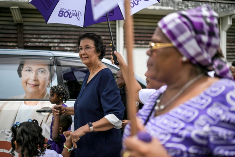 Jennifer Simons (à gauche), candidate du parti NDP, quitte un bureau de vote après avoir voté lors des élections législatives à Paramaribo le 25 mai 2025 ( AFP / Juan BARRETO )
