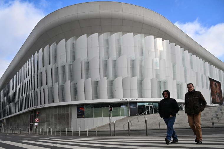 Des piétons marchent devant "La Défense Arena", un stade couvert situé à Nanterre, en banlieue de l'ouest parisien. Photographie prise le 28 novembre 2023. ( AFP / MIGUEL MEDINA )