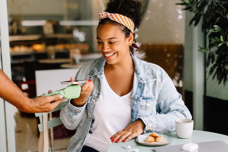 (Crédits photo : Adobe Stock - Jeune femme effectuant un paiement mobile dans un café)