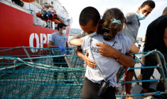 Des migrants débarquent du bateau de sauvetage Open Arms après leur arrivée au port de Messine