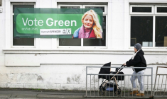 Une habitante passe à côté d'une affiche pour la candidate des Verts pour la législative partielle à Denton, dans le Grand Manchester, le 25 février 2026 ( AFP / Paul ELLIS )