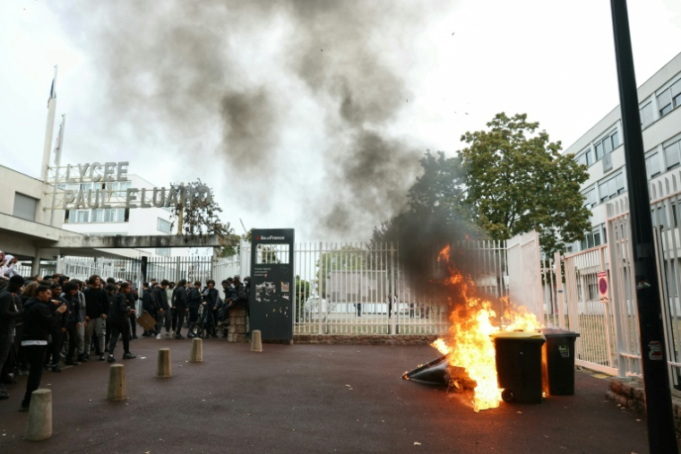 Des lycéens devant un feu de poubelles à l'entrée du lycée Paul-Eluard de Saint-Denis, en Seine-Saint-Denis, le 30 septembre 2026 ( AFP / Thomas SAMSON )