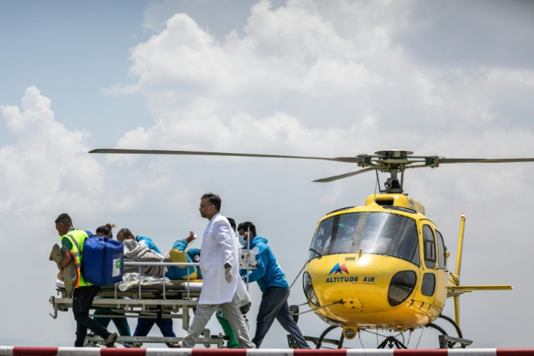 Les secouristes transfèrent Dawa Sherpa après son arrivée à Katmadou au Népal le 4 juin 2026 ( AFP / PRABIN RANABHAT )