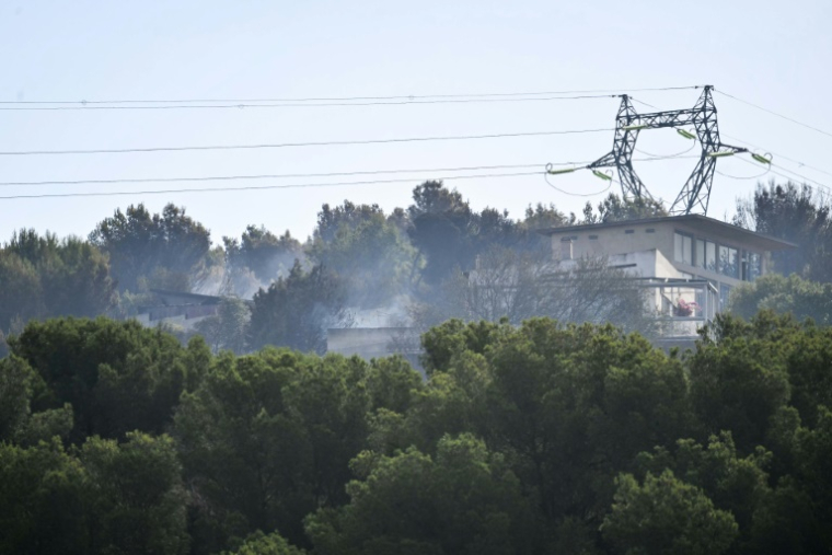 La fumée d'un incendie de forêt près de bâtiments à Saint-Julien Les Martigues, au nord-ouest de Marseille, le 18 juillet 2025 dans les Bouches-du-Rhône ( AFP / Christophe SIMON )
