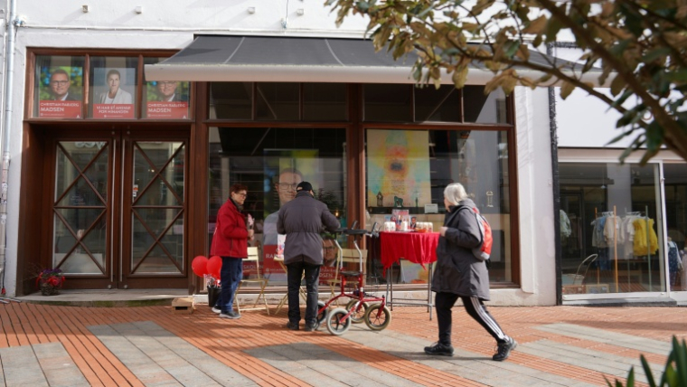 Un habitant discute avec un militant du Parti social-démocrate dans une rue commerçante de Kolding, le 16 mars 2026 au Danemark ( AFP / James Brooks )