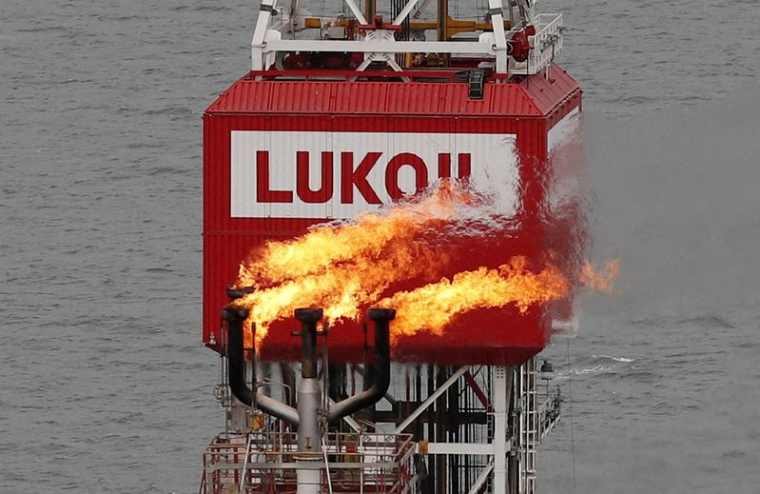 Une torche à gaz est visible à côté du panneau de la société Lukoil sur la plate-forme pétrolière Filanovskogo, dans la mer Caspienne