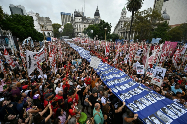 Des manifestants portent une bannière avec des photos de "Disparus" lors d'une manifestation à Buenos Aires le 24 mars 2025 ( AFP / Luis ROBAYO )