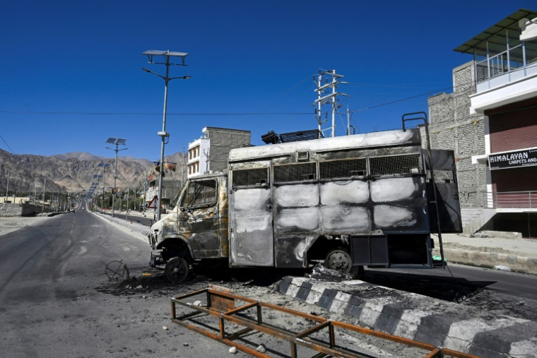 Un véhicule calciné devant les locaux du parti BJP à Leh (extrême nord de l'Inde), où le couvre-feu a été imposé par l'administration après de violents affrontements entre la police et des manifestants, le 25 septembre 2025 ( AFP / TAUSEEF MUSTAFA )