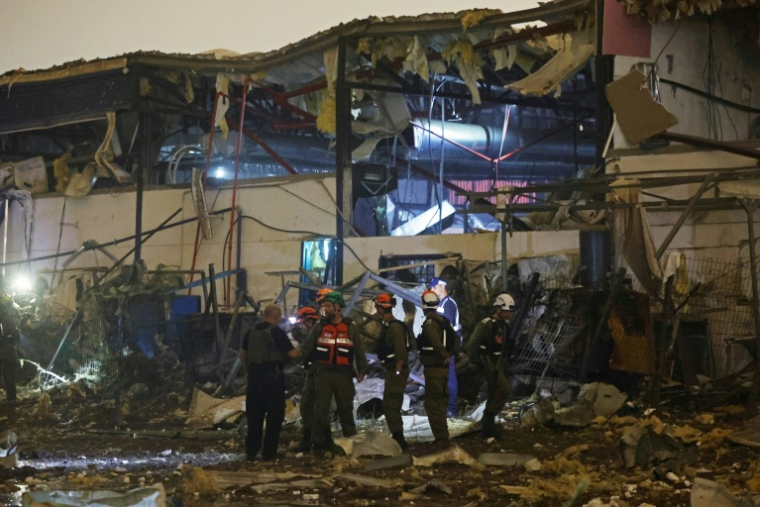 Les forces de sécurité israéliennes et les premiers secours sur le site d’une frappe iranienne qui a touché un quartier résidentiel de Petah Tikva, le 2 avril 2026, en Israël ( AFP / Jack GUEZ )