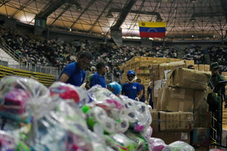 Des soldats distribuent de l'aide dans un complexe sportif à Maiquetia au Venezuela le 3 juillet 2026 ( AFP / Rosali HERNANDEZ )