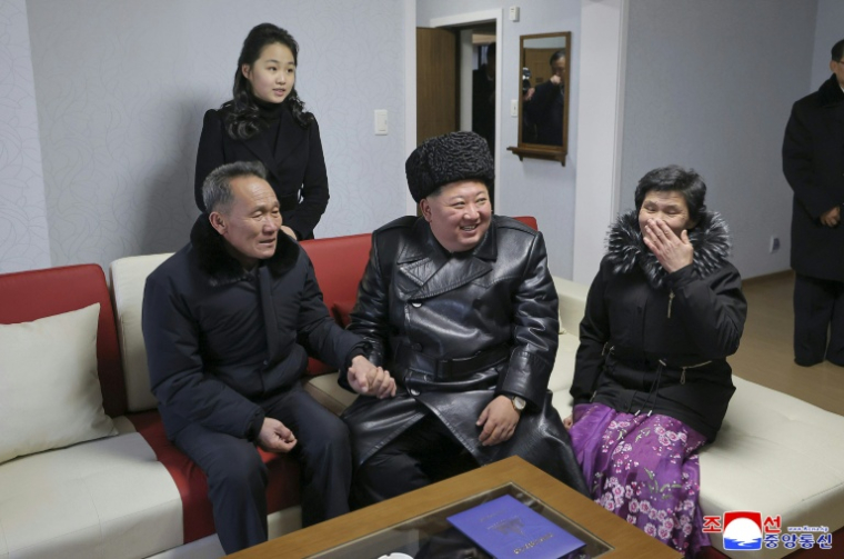 Photo prise le 15 février 2026 et diffusée le 16 février 2026 par l'agence de presse officielle nord-coréenne KCNA, montrant le dirigeant nord-coréen Kim Jong Un (c) et sa fille Ju Ae (à l'arrière,g) rendant visite aux familles de soldats tués en combattant aux côtés de la Russie contre l'Ukraine, dans leurs logements de la nouvelle rue Saeppyol à Pyongyang ( KCNA VIA KNS / STR )