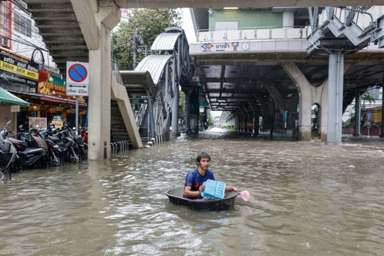 Un homme se déplace dans l'eau inondant le district de Bang Bua à Bangkok, la capitale thaïlandaise, le 26 septembre 2026 ( AFP / WIKUS DE WET )