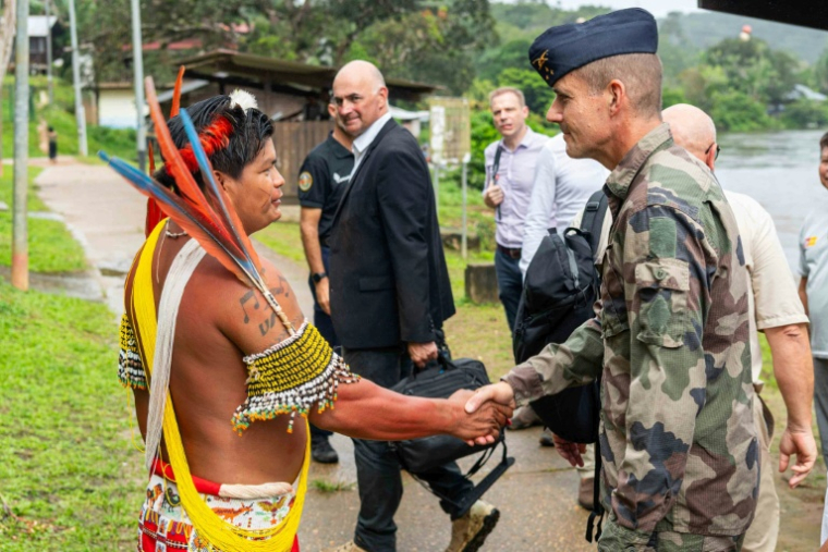 Photo diffusée le 11 mai 2026 par les Forces armées françaises de Guyane du chef coutumier Teko, Mathias Barcarel (g), accueillant le général de division aérienne Géraud Laborie à son arrivée à Camopi, ville frontalière du Brésil où les habitants manifestent contre les passages de frontière des orpailleurs illégaux, en Guyane ( Forces armées françaises de Guyane / Handout )