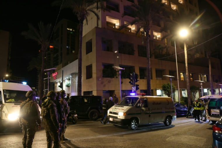 Des secouristes et des membres des forces de l'odre autour devant l'hôtel Ramada touché par une frappe israélienne, le 8 mars 2026 à Beyrouth  ( AFP / IBRAHIM AMRO )