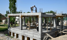 Des ouvriers construisent une bibliothèque, une salle de conférence et une salle de sport pour les femmes, financées par les contributions des travailleurs migrants kirghizes à l'étranger, dans le village de Kyzyl-Jol, le 21 mai 2025 au Kirghizstan ( AFP / Guliza Urustambek kyzy )
