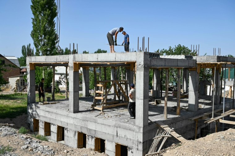 Des ouvriers construisent une bibliothèque, une salle de conférence et une salle de sport pour les femmes, financées par les contributions des travailleurs migrants kirghizes à l'étranger, dans le village de Kyzyl-Jol, le 21 mai 2025 au Kirghizstan ( AFP / Guliza Urustambek kyzy )