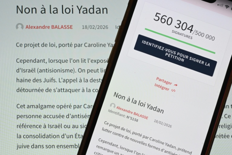 Cette photo prise le 8 avril 2026 à Mulhouse, dans l'est de la France, montre un smartphone et un écran d'ordinateur affichant une page du site web de l'Assemblée nationale française indiquant qu'une pétition intitulée "Non à la loi Yadan" a recueilli plus d'un demi-million de signatures. ( AFP / SEBASTIEN BOZON )