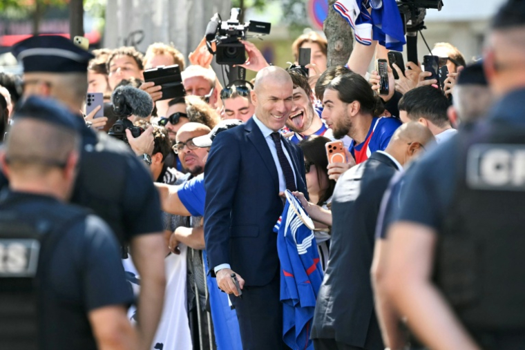 Le nouveau sélectionneur de l'équipe de France Ziénédine Zidane prend des photos avec les supporters devant le siège de la FFF, le 28 juillet 2026 à Paris ( AFP / LOU BENOIST )
