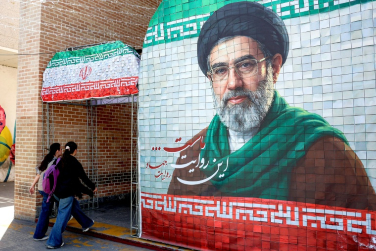 Des femmes passent devant un portrait de l'actuel guide suprême iranien, l'ayatollah Mojtaba Khamenei, dans une rue à Téhéran, le 6 mai 2026 ( AFP / - )