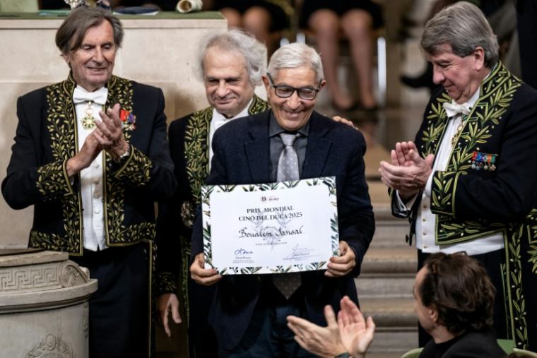 L'écrivain franco-algérien Boualem Sansal (c), entouré par les membres de l'Académie français, Daniel Rondeau (g), Amin Maalouf (c,g) et Xavier Darcos (d), reçoit le prix Cino del Duca à l'Académie française, à Paris, le 4 décembre 2025 ( AFP / BERTRAND GUAY )