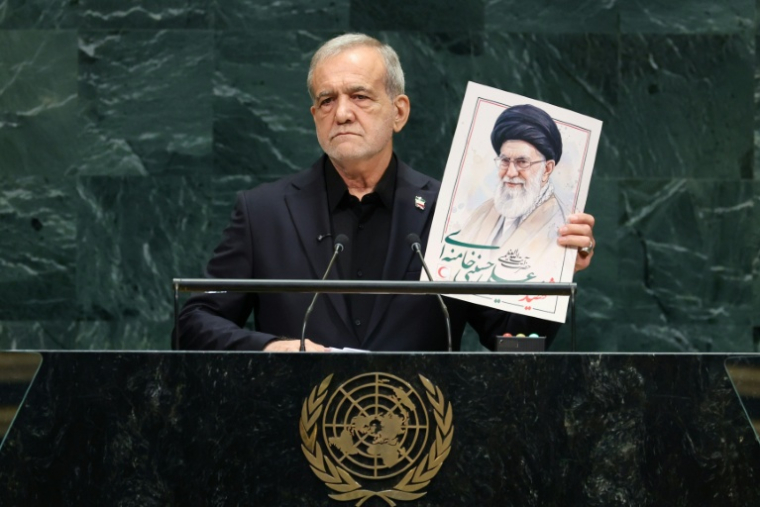 Le président iranien Massoud Pezeshkian tient une photo d'Ali Khamenei, ancien guide suprême de l'Iran, lors de la 81e session de l'Assemblée générale des Nations unies à New York, le 23 septembre 2026 ( AFP / TIMOTHY A. CLARY )