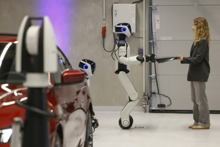 AEON, un robot humanoïde créé par l’entreprise Hexagon, remet une pièce destinée à une voiture alors qu’il est présenté par le consructeur automobile BMW à Munich (Allemagne), le 27 février 2026 ( AFP / Michaela STACHE )