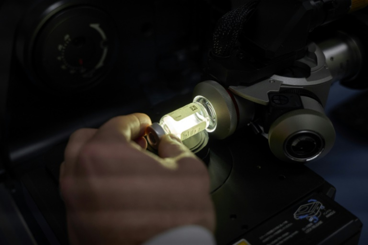 Un technicien de laboratoire utilise un microscope pour examiner un vaccin contrefait dans le laboratoire central d'analyse des contrefaçons de Sanofi, le 18 mars 2025 à Tours ( AFP / GUILLAUME SOUVANT )