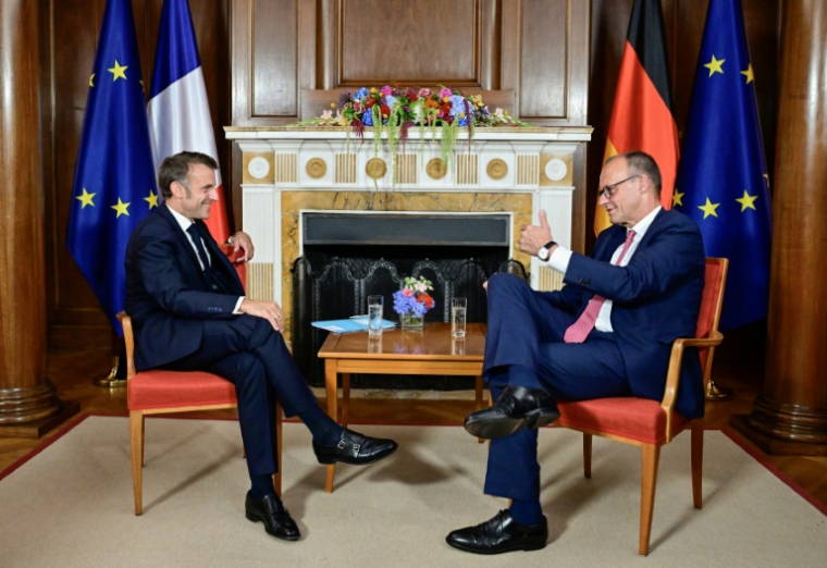 Le chancelier allemand Friedrich Merz et le président Emmanuel Macron s'entretiennent dans la bibliothèque de la Villa Borsig, maison d'hôtes du ministère allemand des Affaires étrangères, à Berlin, le 23 juillet 2025 ( POOL / John MACDOUGALL )