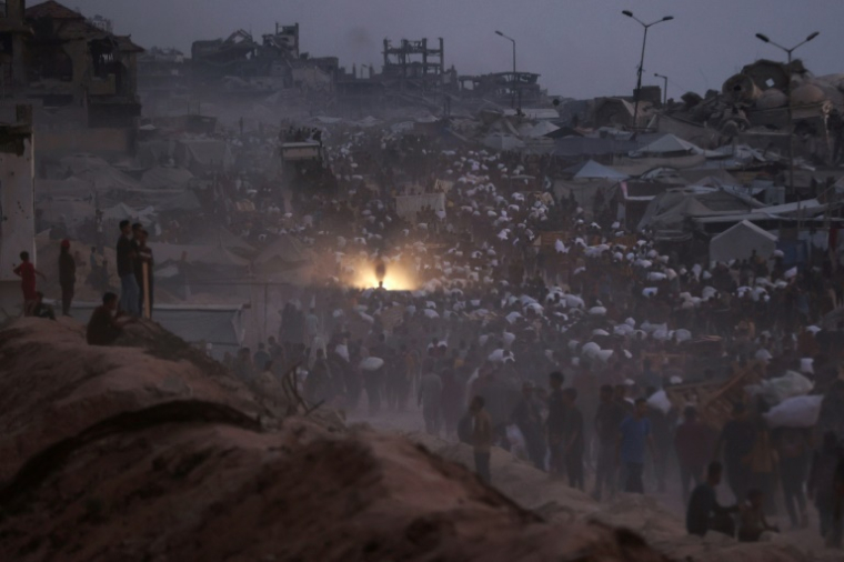 Des Palestiniens transportent des colis d'aides reçus à Beit Lahia dans le centre de la bande de Gaza, le 29 juillet 2025 ( AFP / Omar AL-QATTAA )
