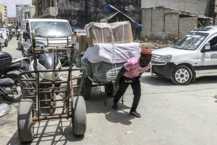 Un homme tire des marchandises dans le centre de Dakar, la capitale sénégalaise, le 2 septembre 2026 ( AFP / PATRICK MEINHARDT )