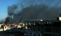 De la fumée noire s'élève au-dessus des bâtiments dans la ville de Soueida, dans le sud de la Syrie, aprè des affrontements communautaires, le 19 juillet 2025 ( AFP / Shadi AL-DUBAISI )