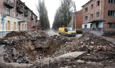 Photo d'archives d'une camionnette passant devant un cratère sur la route après un tir de missile dans la région de Bakhmout