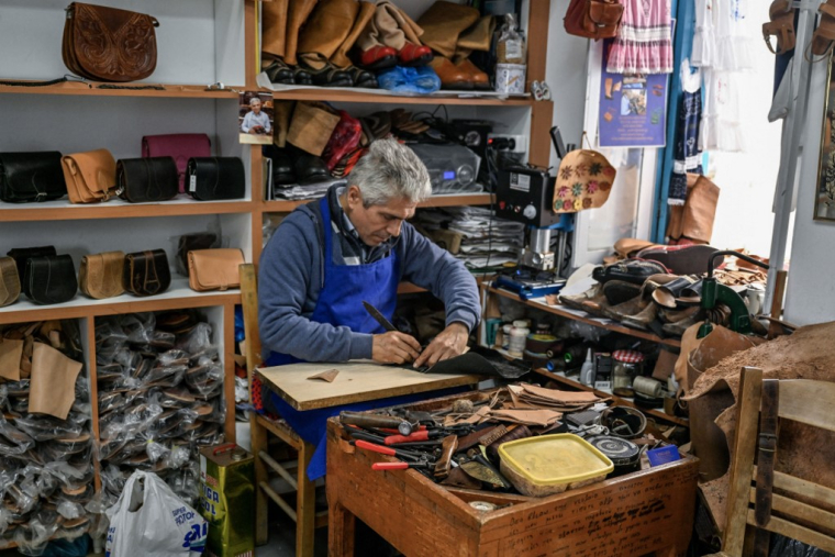 Un cordonnier à Olympos en Grèce, le 6 mai 2023.  ( AFP / LOUISA GOULIAMAKI )