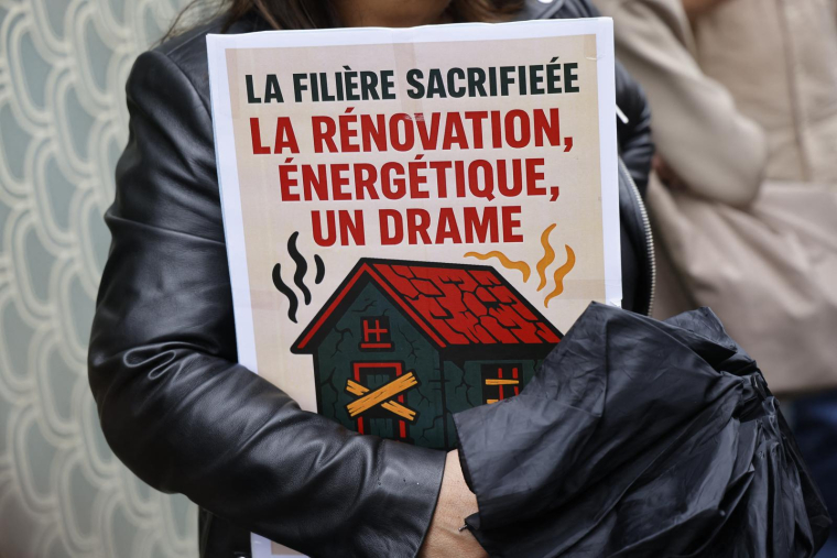 "L'industrie sacrifiée" peut-on lire sur cette pancarte lors d'une manifestation de salariés du secteur de la rénovation. Ils demandent des conditions de paiement raisonnables pour l'aide de l'État "Ma Prime Renov" concernant les travaux de rénovation énergétique devant le siège de l'Agence nationale de l'habitat (ANAH) à Paris le 12 mai 2025. ( AFP / LUDOVIC MARIN )