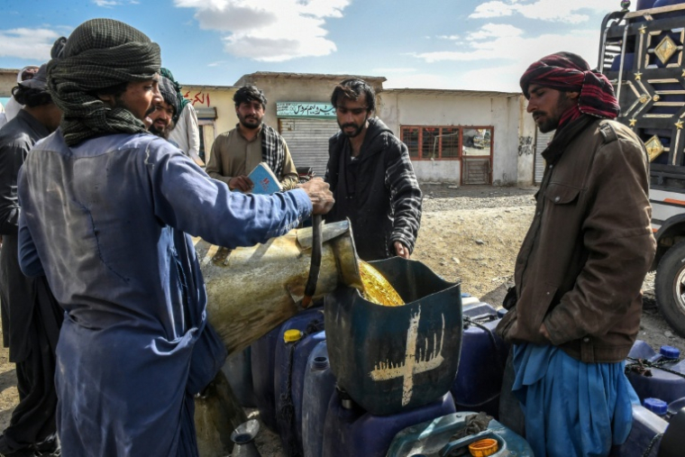 Des vendeurs remplissent des bidons de carburant iranien de contrebande, à la périphérie de Quetta, dans la province du Baloutchistan, le 14 mars 2026 au Pakistan  ( AFP / Banaras KHAN )