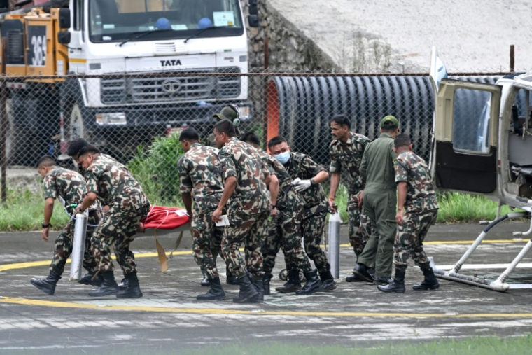 Des militaires évacuent vers un hôpital de Katmandou Kabir Maharjan, survivant des inondations au Népal, qui a été secouru dans le tunnel d'une installation hydroélectrique, le 4 septembre 2026 ( AFP / Arun SANKAR )
