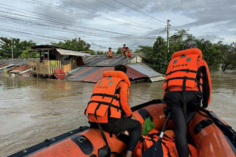 Photo prise le 26 septembre 2025 et publiée le 27 septembre par les garde-côtes philippins montrant le sauvetage d'habitants réfugiés sur le toit de leur maison inondée lors du passage de violente tempête tropicale Bualoi, à Ormoc, aux Philippines ( Garde-côtes philippins / Handout )