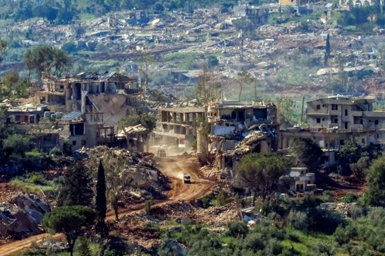 Un véhicule militaire israélien passe devant des maisons détruites par des frappes israéliennes dans le sud du Liban, vu depuis une position de l’autre côté de la frontière, en Haute Galilée, au nord d’Israël, le 7 mai 2026 ( AFP / Jalaa MAREY )