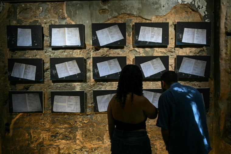 Des visiteurs de l'exposition "Hkeeli ya Jnoub" (Dis-moi, Ô Sud), qui vise à préserver la mémoire des villages détruits par Israël dans le sud du Liban, le 17 juillet 2026 à Beyrouth ( AFP / JOSEPH EID )