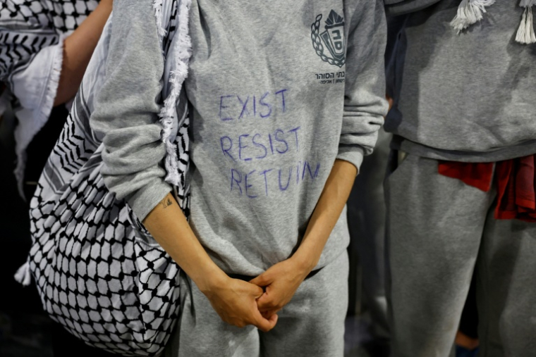 Un militant français, interpellé puis expulsé par Israël à la suite de l'interception de la flottille à destination de Gaza, portant un sweat-shirt sur lequel est inscrit "Exister, résister, revenir", à son arrivée à l'aéroport de Roissy-Charles-de-Gaulle, près de Paris, le 22 mai 2026 ( AFP / SIMON WOHLFAHRT )